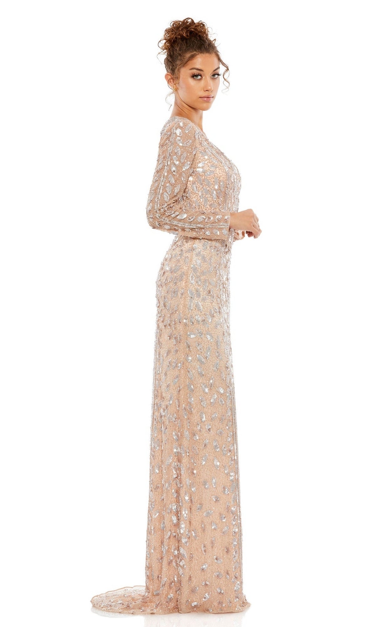 A woman stands in profile against a white background wearing the Long Formal Dress 5002 by Mac Duggal, a floor-length, nude long sleeve gown adorned with silver sequin embellishments.